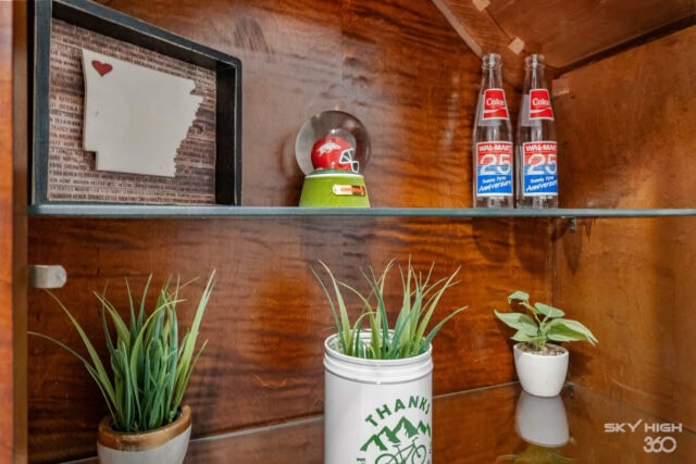 Indoor shelf with plants and vintage memorabilia in Biker’s Basecamp retreat.