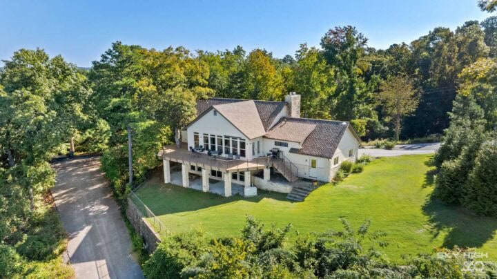 Rivercliff Ridgehouse with lake view in Rogers, AR, surrounded by lush greenery and trees.