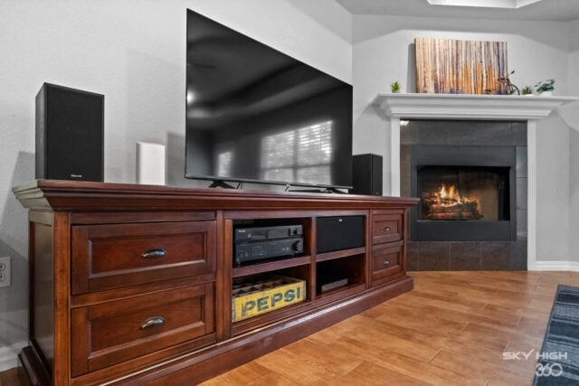 Modern living room with TV, fireplace, and wooden entertainment center in Bella Vista retreat.