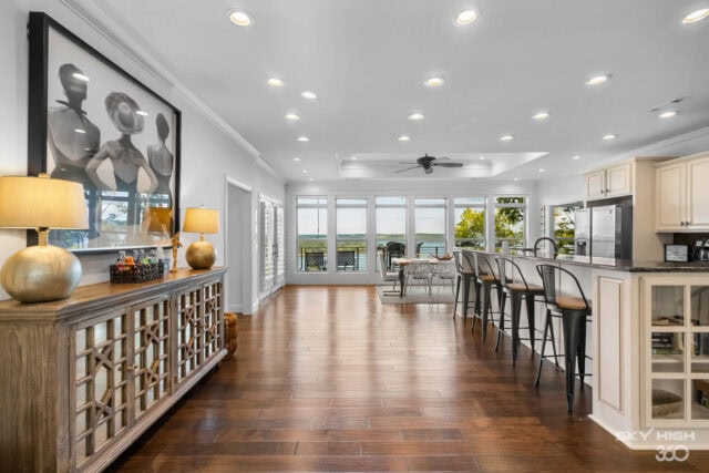 Bright, spacious vacation rental interior with modern kitchen, bar seating, and large windows overlo.