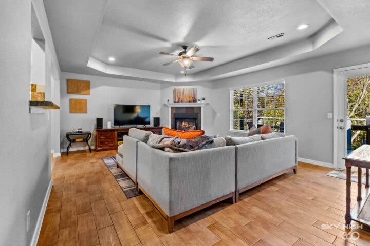 Spacious living room with comfortable seating, fireplace, and large windows in Bella Vista near Back.
